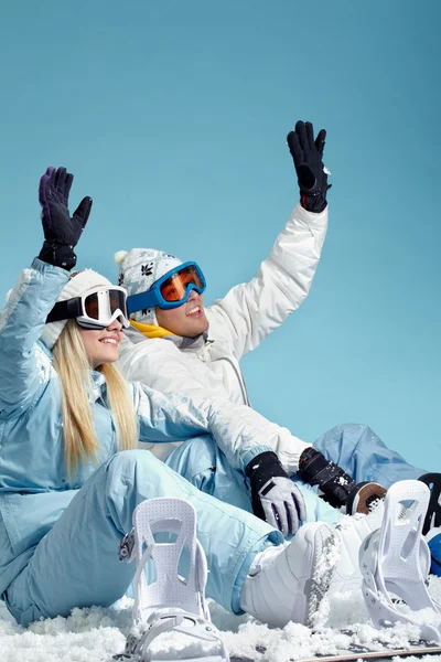Gelukkig snowboarders zittend op sneeuw — Stockfoto
