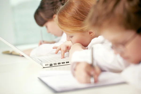 Маленькая девочка с помощью компьютера в школе — стоковое фото