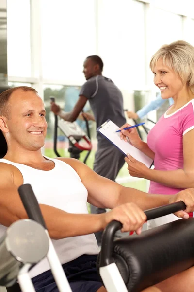 Man träning med instruktör i gymmet — Stockfoto