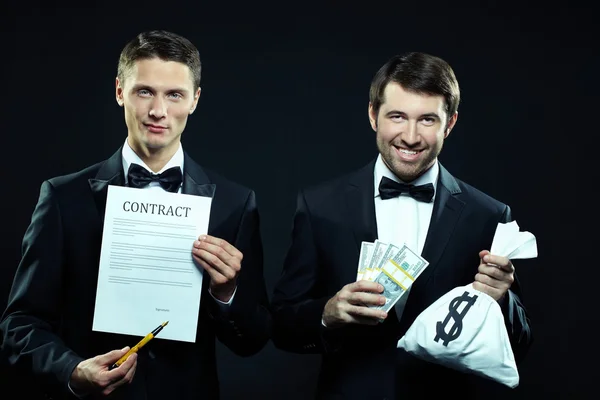 Mannen houden van contract en zak met dollars — Stockfoto