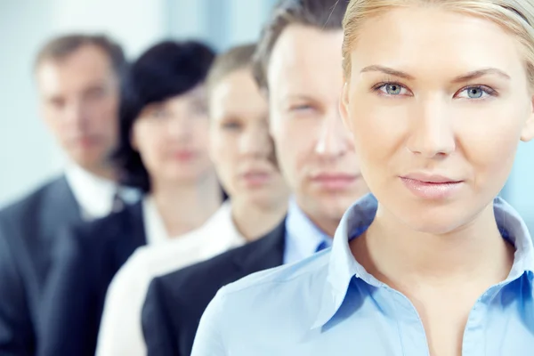 Zakenvrouw met haar team kijken camera — Stockfoto