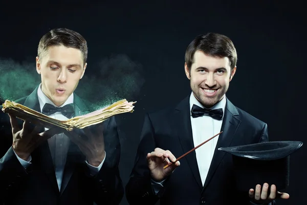 Two men in tuxedos with magic book — Stock Photo, Image