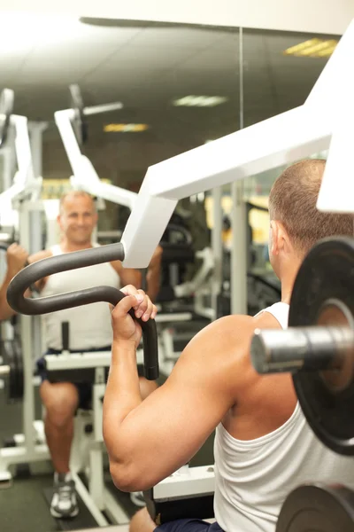 Young man warming up with a simulator — Stock Photo, Image