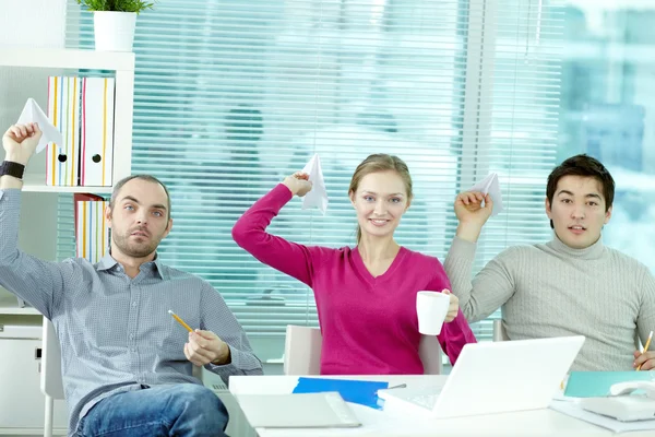 Colleagues with paper airplanes during break — Stock Photo, Image