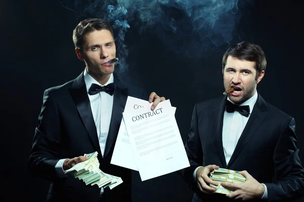 Businessmen showing contracts and money — Stock Photo, Image