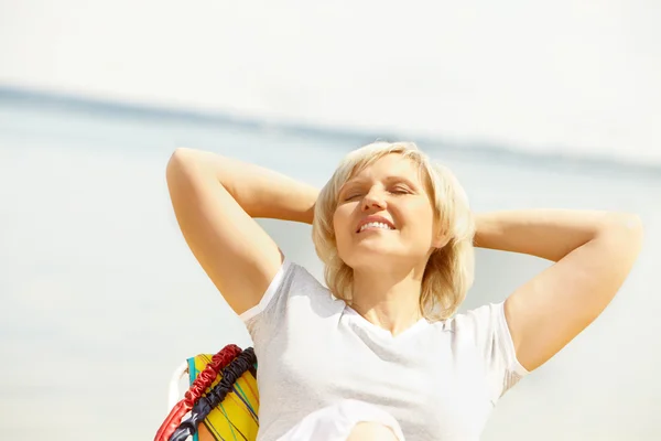 Mature woman resting in chaise lounge — Stock Photo, Image