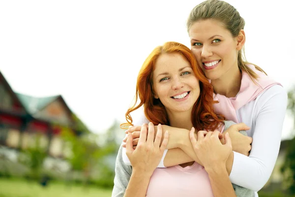 Frauen umarmen sich und blicken in die Kamera — Stockfoto