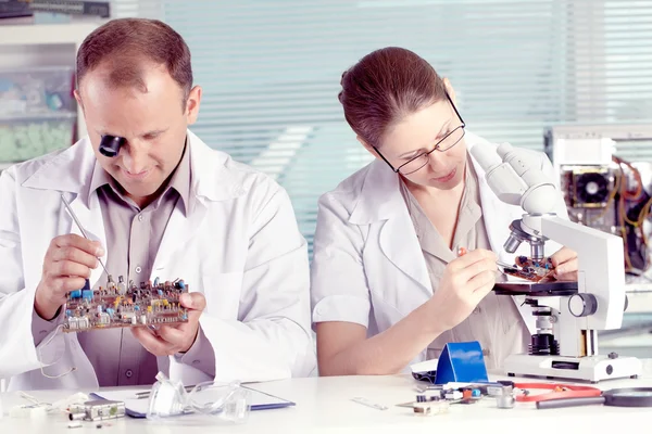 Инженеры, работающие с транзистором в лаборатории — стоковое фото