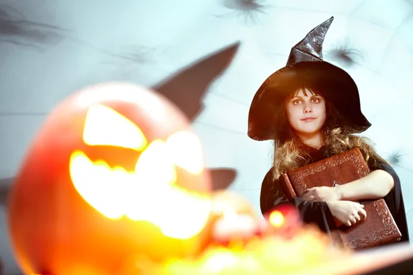 Dziewczynka w kapelusz czarownicy z książką — Zdjęcie stockowe