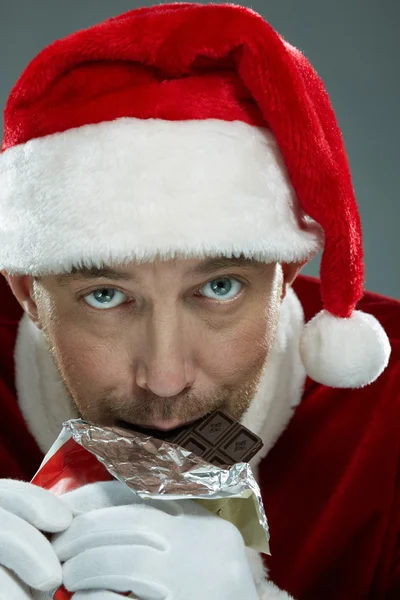 Дед Мороз кусает шоколад — стоковое фото