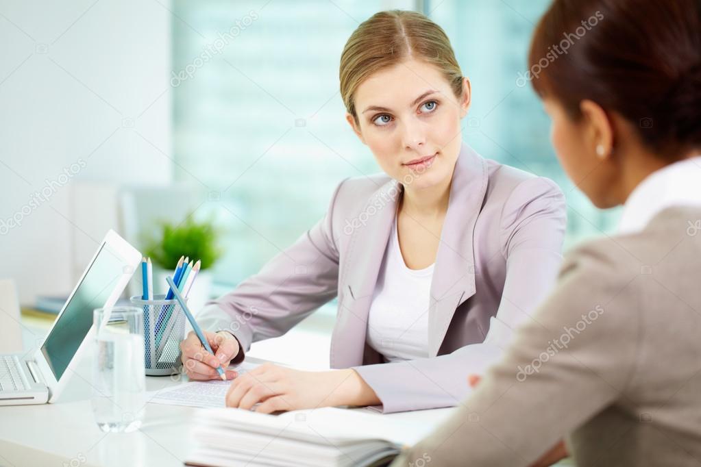 Serious businesswoman listening to woman 