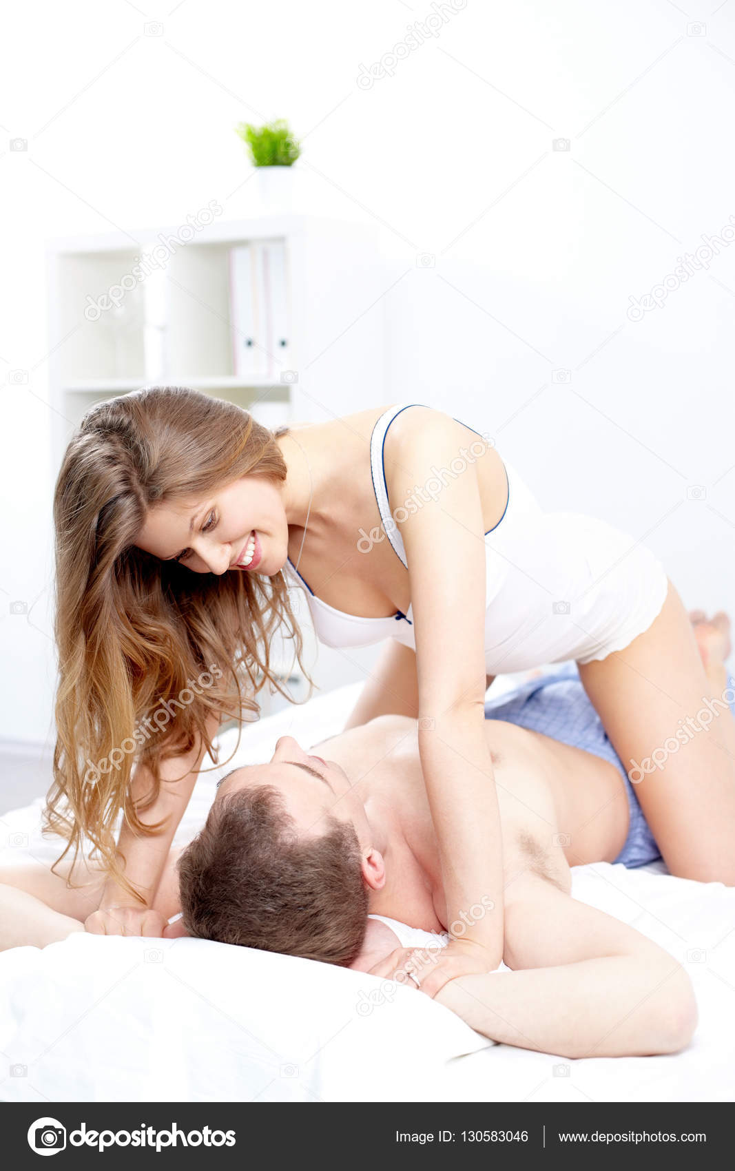 Woman seducing a man in bed Stock Photo by ©pressmaster 130583046
