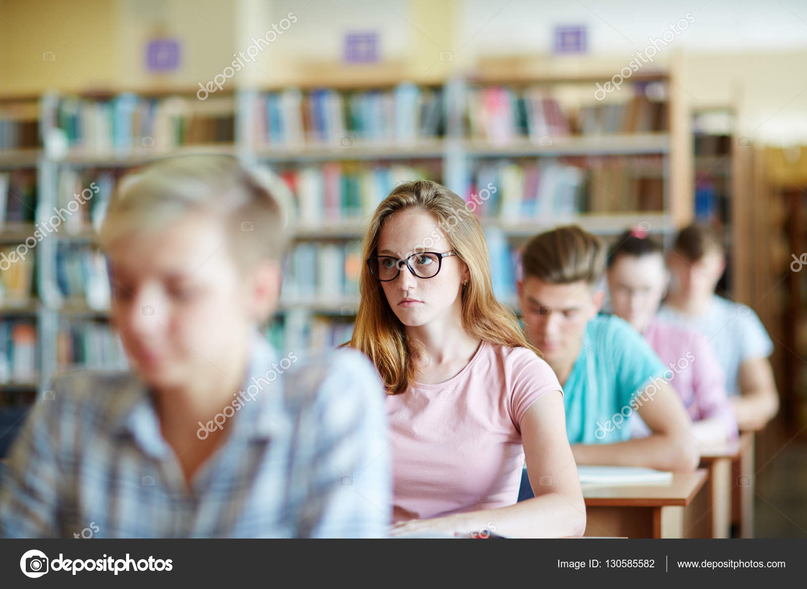Будет сидеть на уроке и. Группа подростков за чтением. Девушка сидит в телефоне на уроке. Картинка девушка смотрит в камеру на уроке. Человек сидит на уроке фото.
