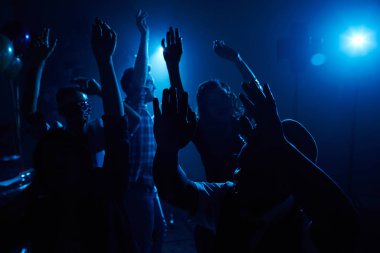Gece kulübünde dans eden bir grup insan.