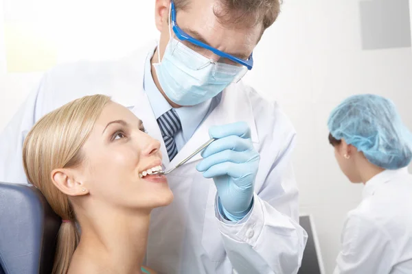 Dentista examinando los dientes de sus pacientes — Foto de Stock