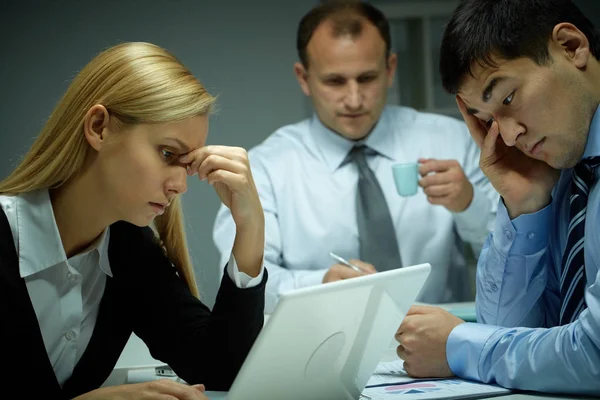 Drie mensen uit het bedrijfsleven werken laat in kantoor — Stockfoto