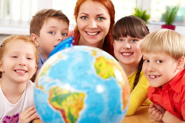 Insegnante e piccoli studenti guardando la fotocamera — Foto Stock