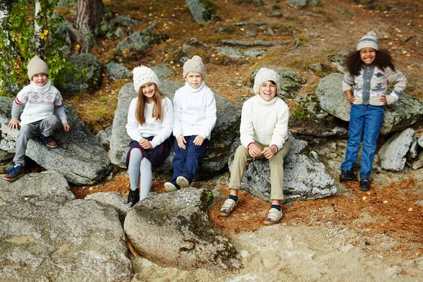 Schattige kinderen zitten op stenen — Stockfoto