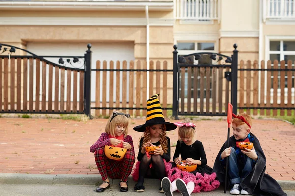 Crianças de Halloween escolhendo doces em recipientes — Fotografia de Stock