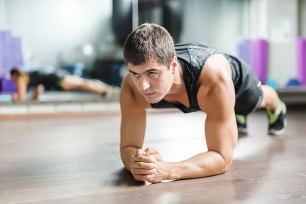 Muscular athlete doing physical exercise — Stock Photo, Image