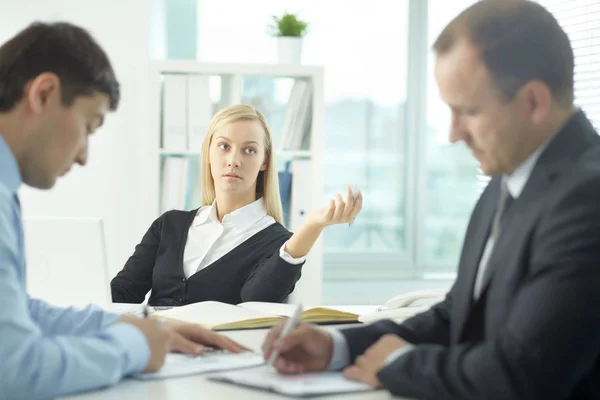 Mulher de negócios séria que comunica com seus colegas — Fotografia de Stock