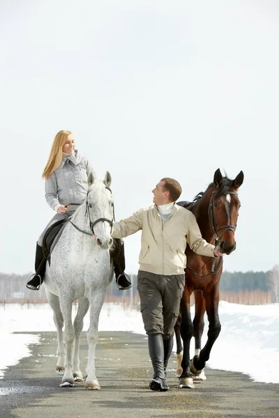 Mulher e homem montando cavalos — Fotografia de Stock