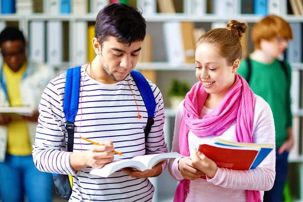 Estudiantes amistosos leyendo algo en el libro —  Fotos de Stock