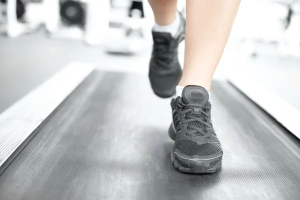 Piernas femeninas corriendo en la cinta de correr — Foto de Stock