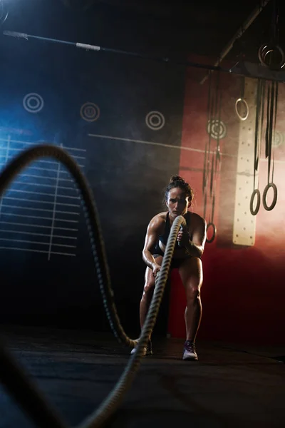 Mujer tirando de cuerdas en el gimnasio — Foto de Stock