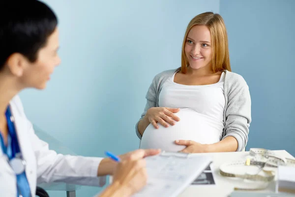 Беременная женщина слушает своего врача — стоковое фото