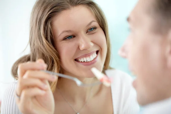 Jonge vrouw haar echtgenoot voeding — Stockfoto