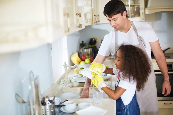 Girl washing dishes with father — Stock Photo, Image