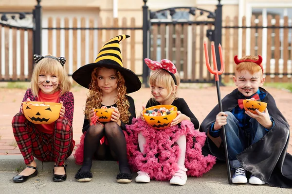 Enfants avec des bols de citrouille plein de bonbons — Photo