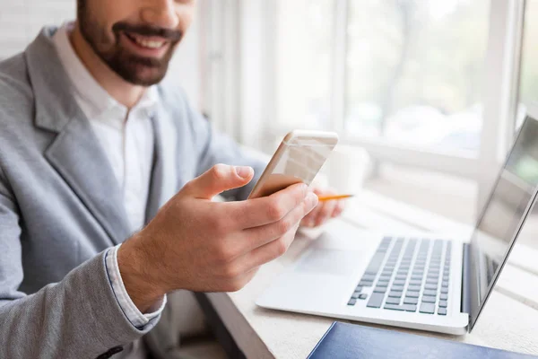 Empresario usando smartphone y laptop — Foto de Stock