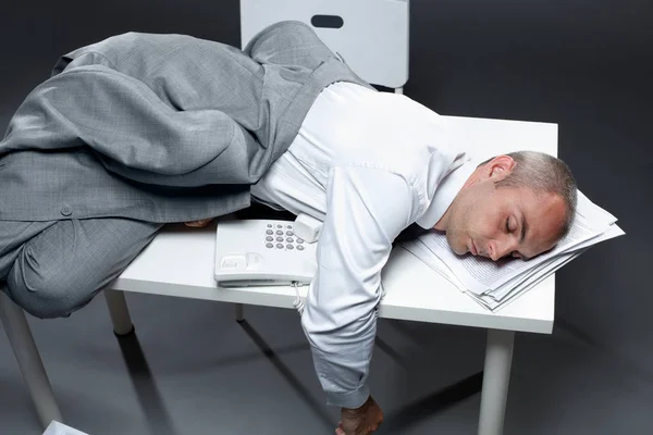 Büroangestellter schläft auf seinem Tisch — Stockfoto