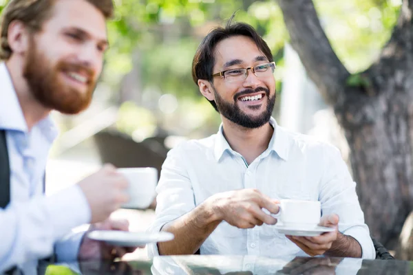 Uomini d'affari con caffè che parlano con un collega — Foto Stock