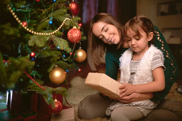 Dívka s zabalené vánoční dárek od své matky — Stock fotografie