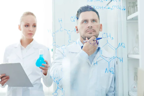 Kemist med assistent vid kemisk formel — Stockfoto