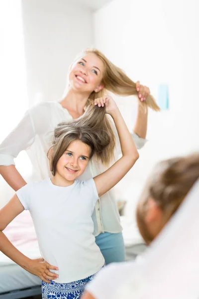 Mother and daughter looking at their hair — Stock Photo, Image