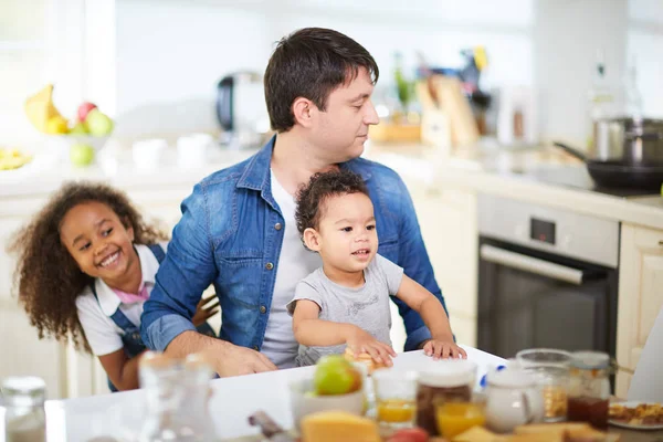 Vader en kinderen zitten in de keuken — Stockfoto