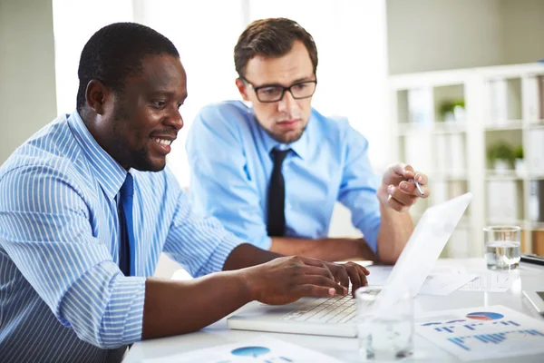 Männliche Kollegen diskutieren über Daten am Laptop — Stockfoto