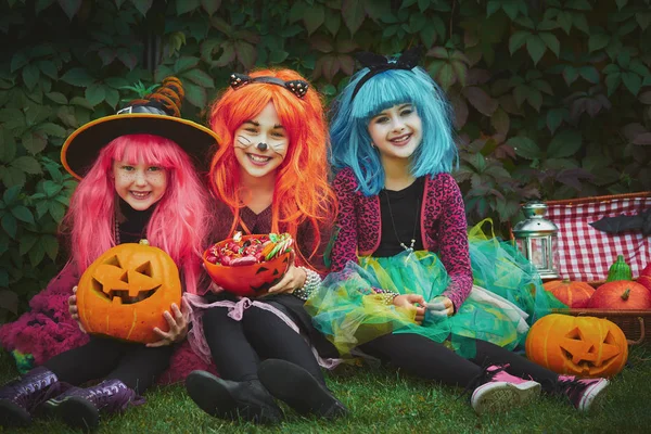 Three witches in wigs sitting on grass — Stock Photo, Image