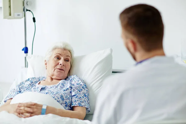 Старшая пациентка разговаривает со своим врачом — стоковое фото