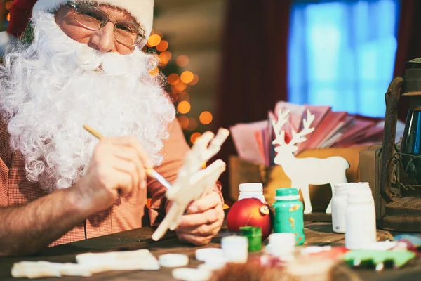 Улыбающийся Санта украшает игрушки — стоковое фото