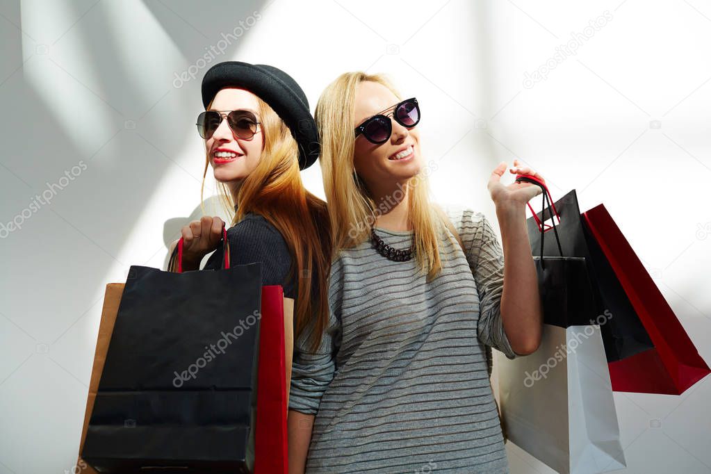 Stylish women holding paper bags