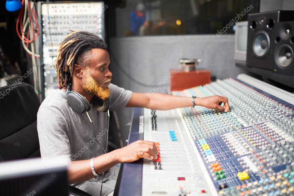 Deejay adjusting sounds in audio studio