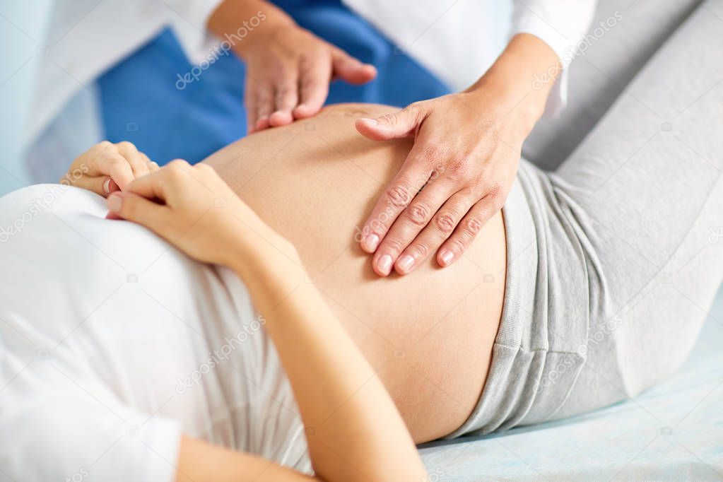 Checking up belly of pregnant woman