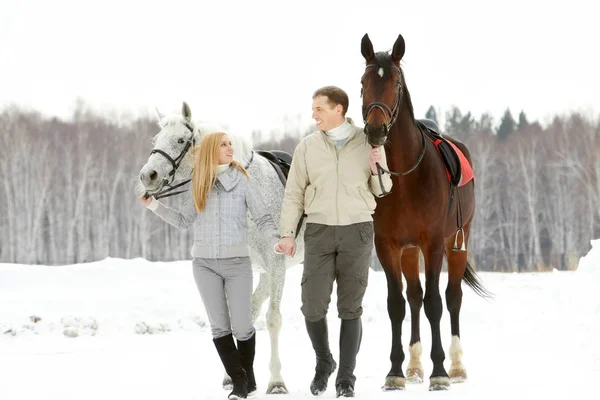 Pareja liderando sus caballos — Foto de Stock