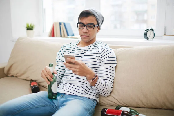 Gars avec bouteille vide et téléphone portable — Photo