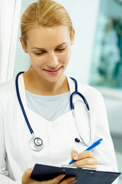 Junge Ärztin macht sich Notizen — Stockfoto